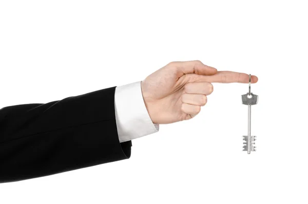Tema de negócios: agente imobiliário na jaqueta em sua mão a chave para um novo apartamento no fundo isolado branco — Fotografia de Stock