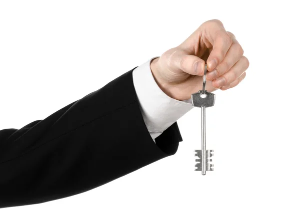 Tema de negócios: agente imobiliário na jaqueta em sua mão a chave para um novo apartamento no fundo isolado branco — Fotografia de Stock