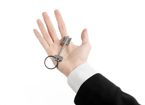 Business theme: real estate agent in the jacket in his hand the key to a new apartment on the white isolated background — Stock Photo, Image