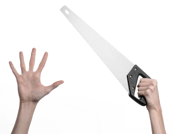 Construction topic: hand holding a saw with a black pen on a white background isolated — Stock Photo, Image