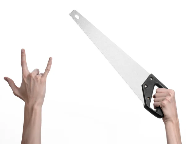 Construction topic: hand holding a saw with a black pen on a white background isolated — Stock Photo, Image