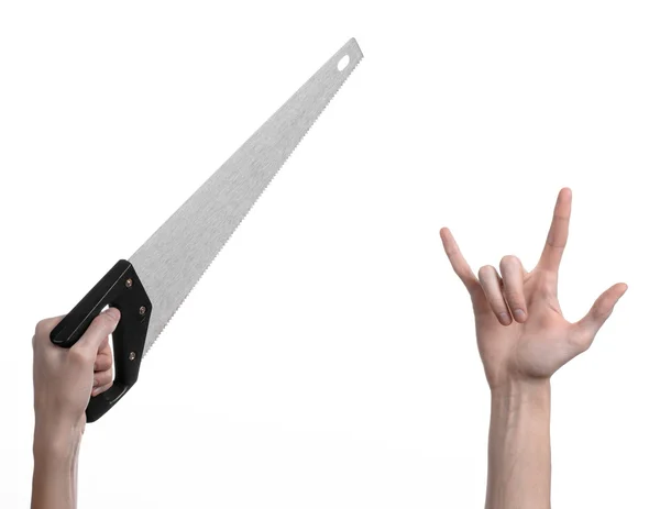 Construction topic: hand holding a saw with a black pen on a white background isolated — Stock Photo, Image
