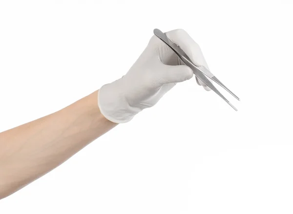 Тема медицины и хирургии: рука врача в белой перчатке с пинцетом на белом фоне — стоковое фото