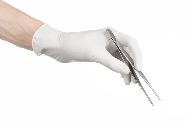 Medycyna i chirurgia tematu: ręka lekarza w białych rękawiczkach, trzymając pęsety na białym tle — Zdjęcie stockowe