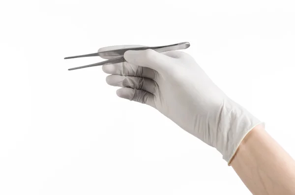 Тема медицини та хірургії: рука лікаря в білій рукавичці, що тримає пінцет ізольовано на білому тлі — стокове фото