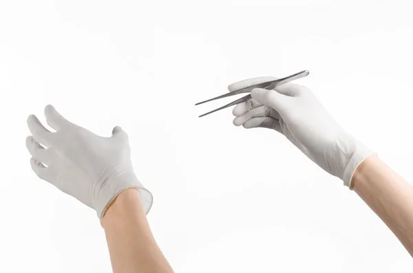 Tema Medicina y Cirugía: Mano del médico en un guante blanco con pinzas aisladas sobre fondo blanco — Foto de Stock