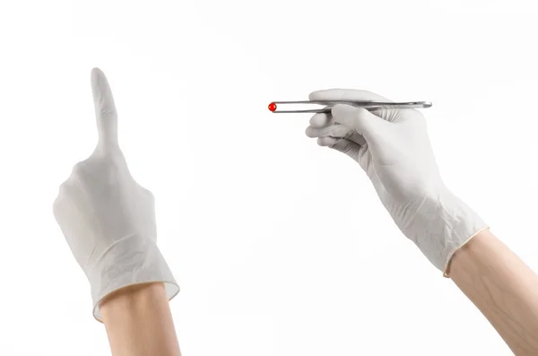 Pharmacology and Medical theme: doctor's hand in a white glove holding tweezers with red pill capsule isolated on white background in studio — Stock Photo, Image