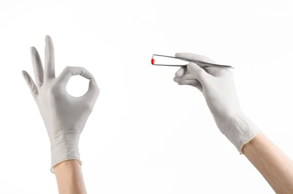 약 학 및 의학 테마: 빨간 알 약 캡슐 스튜디오에서 흰색 배경에 고립으로 족집게를 들고 흰 장갑에 의사의 손을 — 스톡 사진