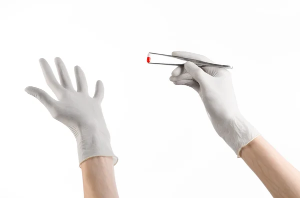 薬理学および医学のテーマ: studio で白い背景で隔離赤い錠剤カプセルとピンセットを持って白い手袋で医師の手 — ストック写真
