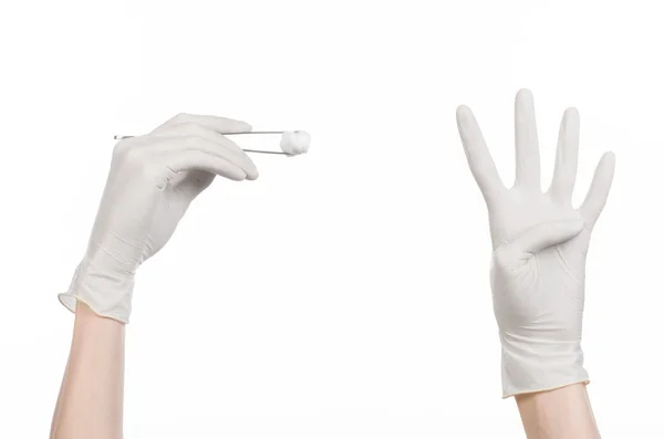 Тема медицины и хирургии: рука врача в белой перчатке с пинцетом и мазком на белом фоне в студии — стоковое фото