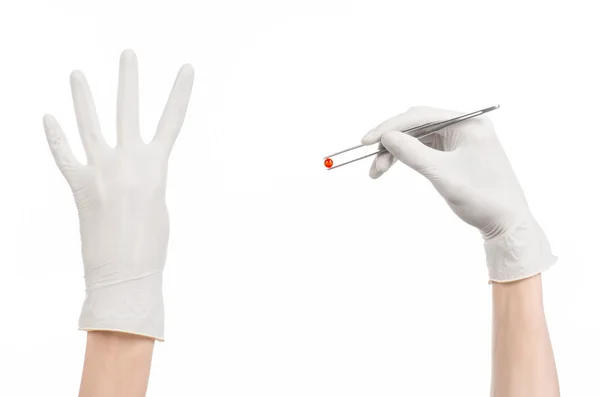 Pharmacology and Medical theme: doctor's hand in a white glove holding tweezers with red pill capsule isolated on white background in studio — Stock Photo, Image