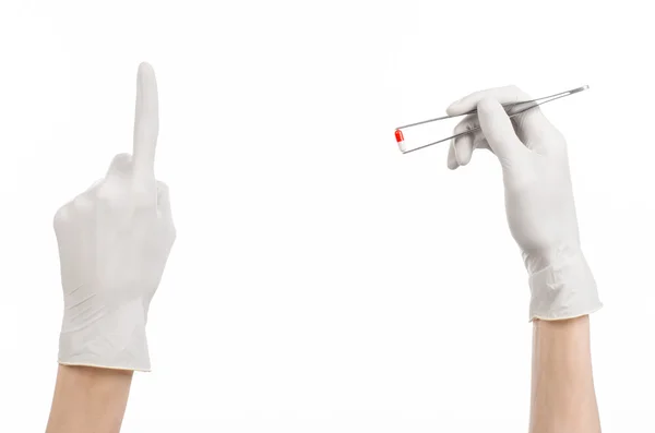 药理学和医疗主题: 医生的手在孤立在工作室中的白色背景上的红色药丸胶囊镊子白色手套 — 图库照片