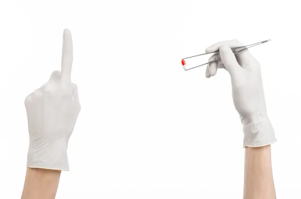 Pharmacology and Medical theme: doctor's hand in a white glove holding tweezers with red pill capsule isolated on white background in studio — Stock Photo, Image