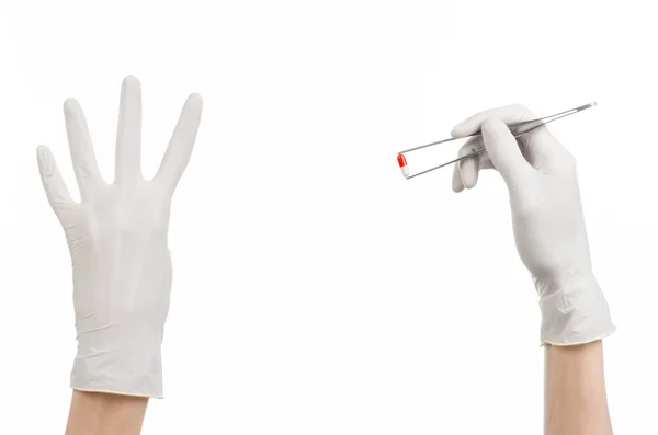 Pharmacology and Medical theme: doctor's hand in a white glove holding tweezers with red pill capsule isolated on white background in studio — Stock Photo, Image