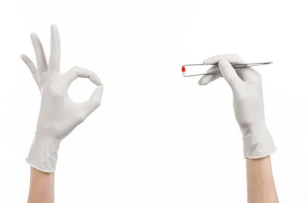 Pharmacology and Medical theme: doctor's hand in a white glove holding tweezers with red pill capsule isolated on white background in studio — Stock Photo, Image