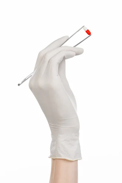 药理学和医疗主题: 医生的手在孤立在工作室中的白色背景上的红色药丸胶囊镊子白色手套 — 图库照片