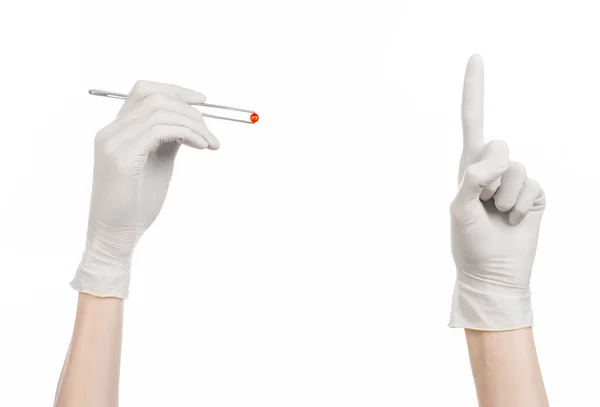 Farmakologia i medycyna tematu: ręka lekarza w białych rękawiczkach, trzymając pęseta z czerwoną pigułkę kapsułki na białym tle na białym tle w studio — Zdjęcie stockowe