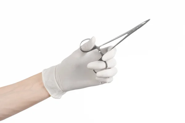 Cirugía y tema médico: la mano del médico en un guante blanco sosteniendo un clip quirúrgico aislado sobre fondo blanco — Foto de Stock