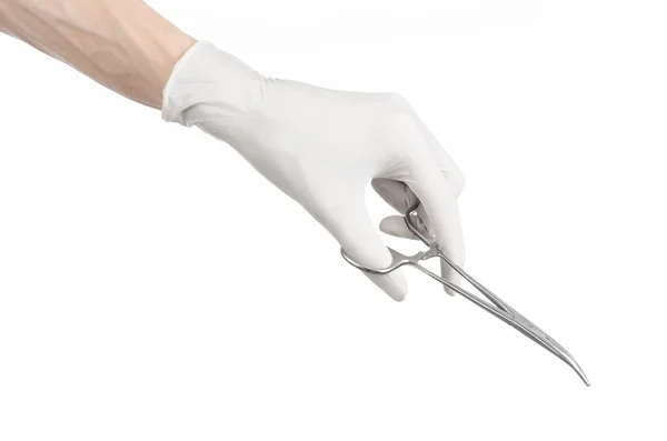 Kirurgi och medicinsk tema: läkarens hand i en vit handske holding ett kirurgiskt klipp isolerad på vit bakgrund — Stockfoto
