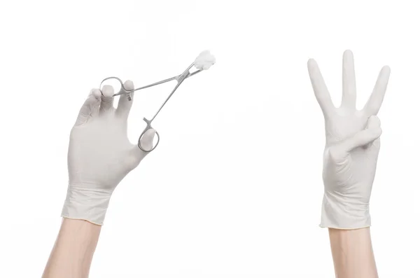 Cirurgia e medicina tema: mão do médico em uma luva branca segurando uma braçadeira cirúrgica com cotonete isolado em fundo branco no estúdio — Fotografia de Stock