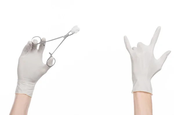 Тема операции и медицины: рука врача в белой перчатке с хирургическим зажимом на белом фоне на белом фоне в студии — стоковое фото