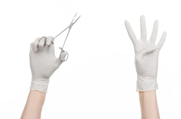 Cirugía y tema médico: la mano del médico en un guante blanco sosteniendo un clip quirúrgico aislado sobre fondo blanco — Foto de Stock