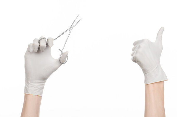 Surgery and Medical theme: doctor's hand in a white glove holding a surgical clip isolated on white background