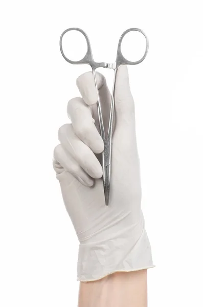 Chirurgie und medizinisches Thema: Die Hand des Arztes in einem weißen Handschuh mit einem Chirurgenclip auf weißem Hintergrund — Stockfoto