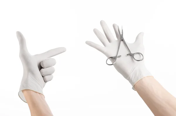 Chirurgie und medizinisches Thema: Die Hand des Arztes in einem weißen Handschuh mit einem Chirurgenclip auf weißem Hintergrund — Stockfoto