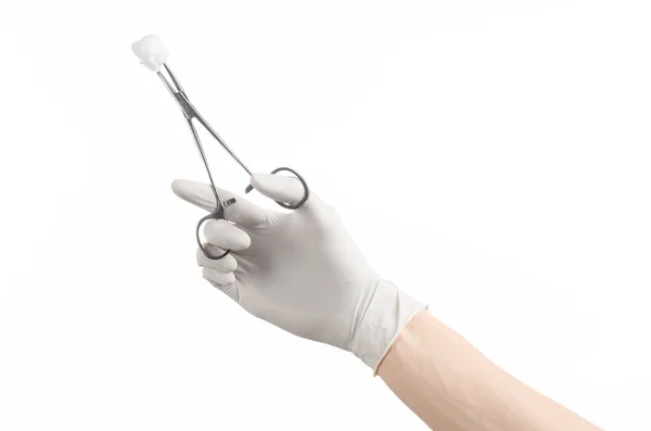 Cirurgia e medicina tema: mão do médico em uma luva branca segurando uma braçadeira cirúrgica com cotonete isolado em fundo branco no estúdio — Fotografia de Stock