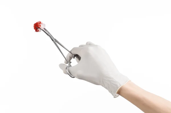 Chirurgie und medizinisches Thema: die Hand des Arztes in einem weißen Handschuh, der einen Chirurgenclip mit einem blutigen Tampon auf weißem Hintergrund im Studio hält — Stockfoto