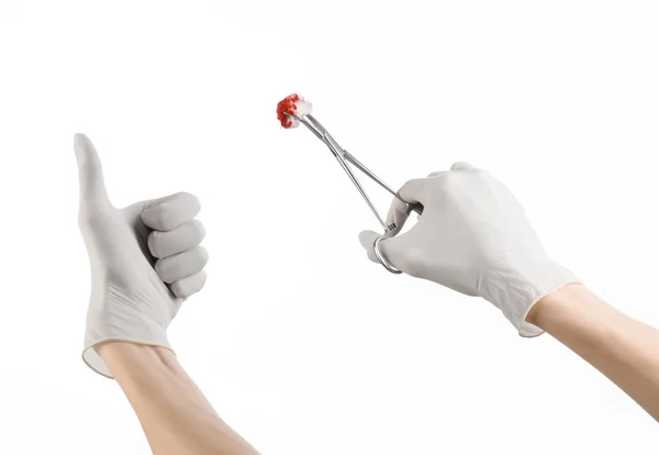 Surgery and Medical theme: doctor's hand in a white glove holding a surgical clip with a bloody tampon isolated on a white background in studio — Stock Photo, Image