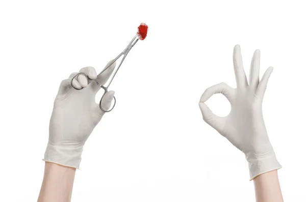 Chirurgie en medische thema: doctor's hand in een witte handschoen houden een chirurgische clip met een bloedige tampon geïsoleerd op een witte achtergrond in studio — Stockfoto