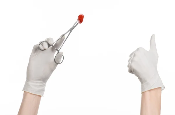 Chirurgie en medische thema: doctor's hand in een witte handschoen houden een chirurgische clip met een bloedige tampon geïsoleerd op een witte achtergrond in studio — Stockfoto