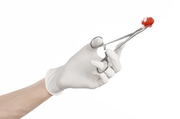 Cirugía y tema médico: la mano del médico en un guante blanco sosteniendo un clip quirúrgico con un tampón ensangrentado aislado sobre un fondo blanco en el estudio —  Fotos de Stock