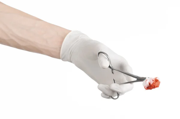 Chirurgie en medische thema: doctor's hand in een witte handschoen houden een chirurgische clip met een bloedige tampon geïsoleerd op een witte achtergrond in studio — Stockfoto