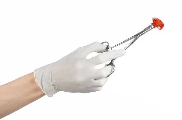 Chirurgie et Thème médical : la main du médecin dans un gant blanc tenant un clip chirurgical avec un tampon ensanglanté isolé sur fond blanc en studio — Photo