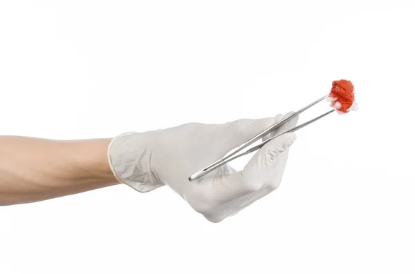 Surgery and Medical theme: doctor's hand in a white glove holding a surgical clip with a bloody tampon isolated on a white background in studio — Stock Photo, Image