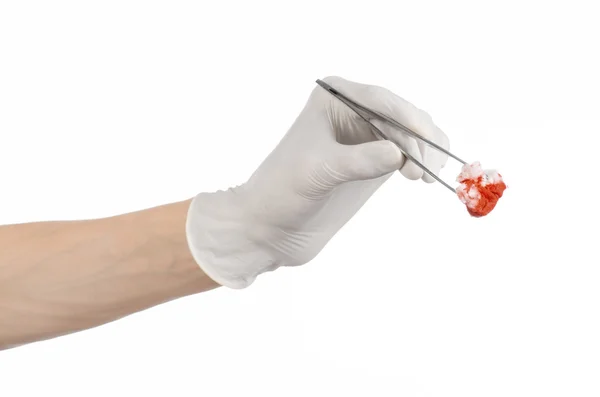 Chirurgia e tema medico: mano del medico in un guanto bianco che tiene una clip chirurgica con un tampone insanguinato isolato su uno sfondo bianco in studio — Foto Stock