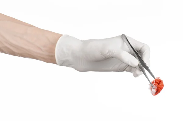 Surgery and Medical theme: doctor's hand in a white glove holding a surgical clip with a bloody tampon isolated on a white background in studio — Stock Photo, Image