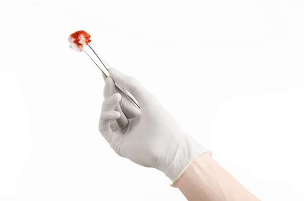 Surgery and Medical theme: doctor's hand in a white glove holding a surgical clip with a bloody tampon isolated on a white background in studio — Stock Photo, Image