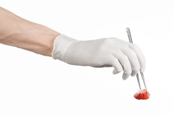 Cirurgia e Tema Médico: a mão do médico em uma luva branca segurando um clipe cirúrgico com um tampão sangrento isolado em um fundo branco no estúdio — Fotografia de Stock