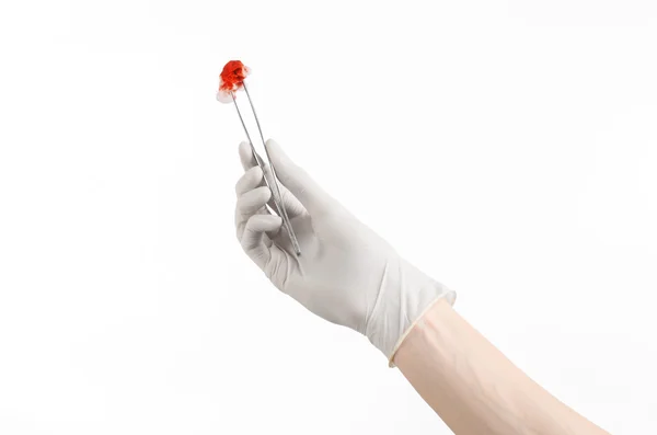 Surgery and Medical theme: doctor's hand in a white glove holding a surgical clip with a bloody tampon isolated on a white background in studio — Stock Photo, Image