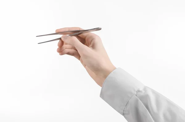 Thème chirurgical et médical : une pince à épiler à la main du médecin isolée sur fond blanc en studio — Photo