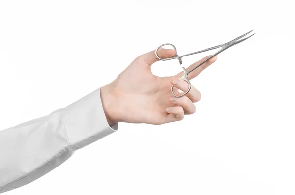 Tema Quirúrgico y Médico: Mano del doctor en una bata de laboratorio blanca sosteniendo una tijera de pinza quirúrgica aislada sobre un fondo blanco en el estudio — Foto de Stock