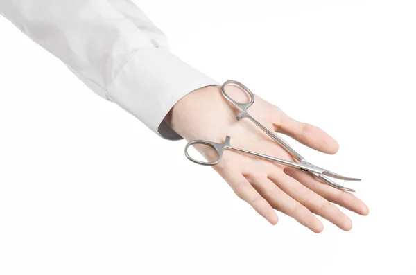 Kirurgisk och medicinsk tema: läkarens hand i en vit labbrock innehar en kirurgisk clamp sax isolerad på en vit bakgrund i studio — Stockfoto