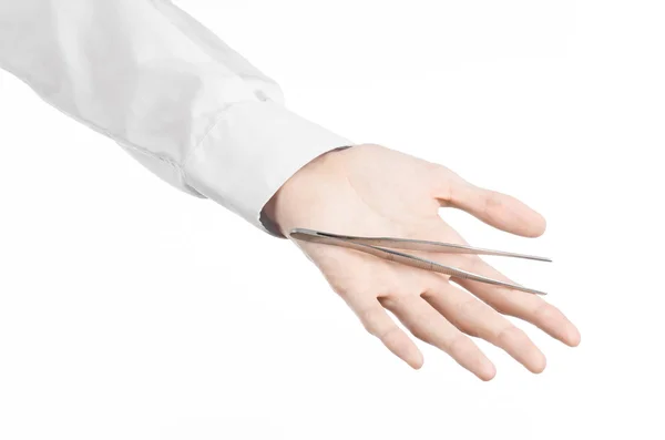 Kirurgisk og medisinsk tema: legens hånd som holder pinsett isolert på hvit bakgrunn i studio – stockfoto