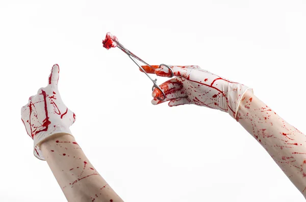 Tema de cirugía y medicina: la mano ensangrentada del médico en el guante sostiene una abrazadera quirúrgica ensangrentada con hisopo y realiza la cirugía sobre un fondo blanco aislado en el estudio —  Fotos de Stock