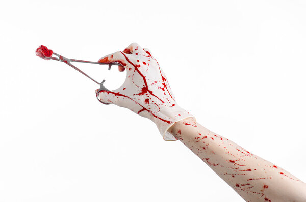 Surgery and medicine theme: doctor bloody hand in glove holding a bloody surgical clamp with swab and performs surgery on an isolated white background in studio