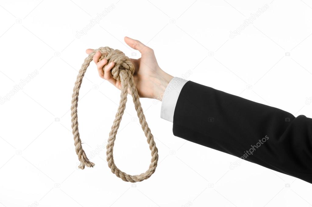 Suicide and business topic: Hand of a businessman in a black jacket holding a loop of rope for hanging on white isolated background